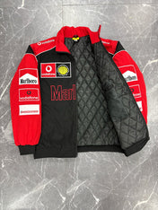 Red and black quilted jacket with various logos on a gray marble surface