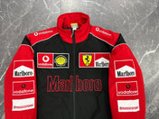 Red and black jacket with various sponsor logos on a textured gray background