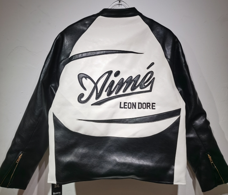 Black and white leather jacket with 'Leon Dore' branding on a plain background