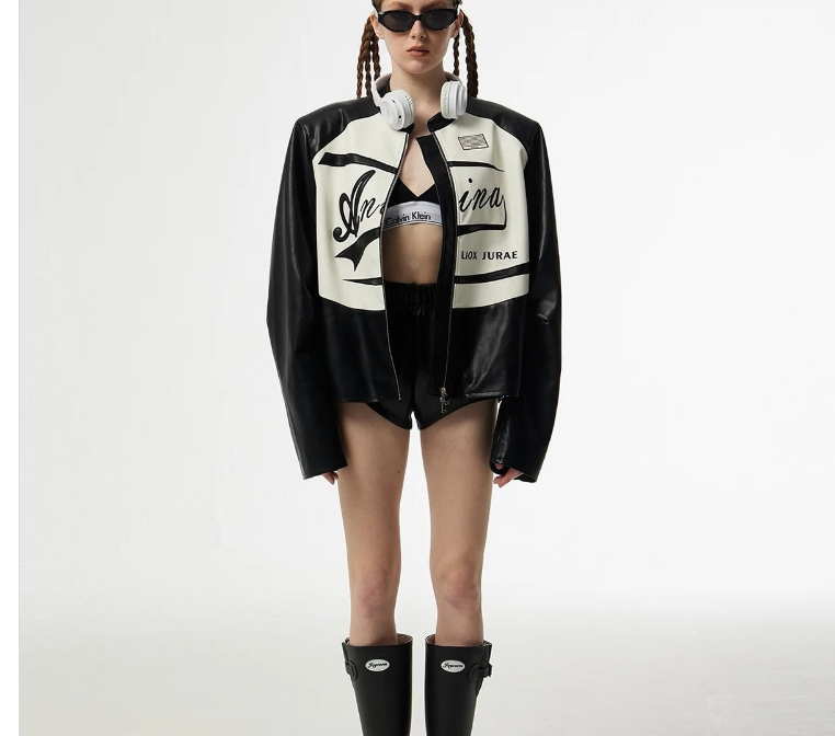 Person wearing a black and white jacket with visible branding on a white background