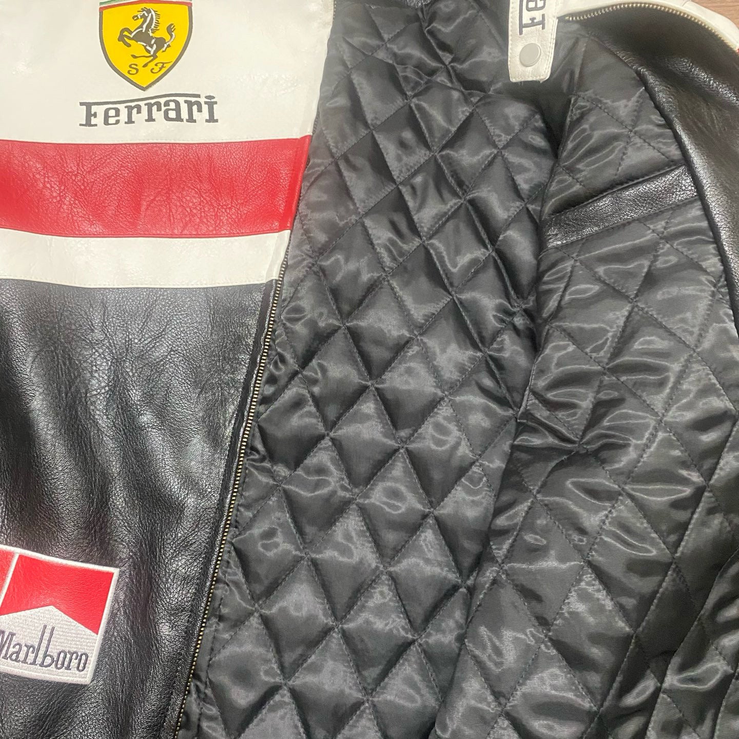 Close-up of a Ferrari branded jacket with quilted black lining.