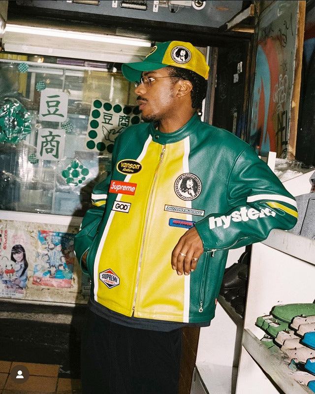 Person wearing a green and yellow jacket with multiple brand logos in an urban setting.