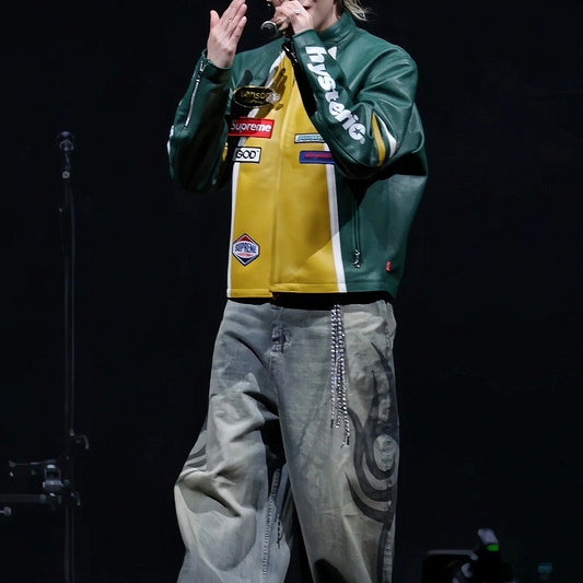 Person on stage wearing a colorful jacket and gray pants, with 'Strawberry' logo in the corner.
