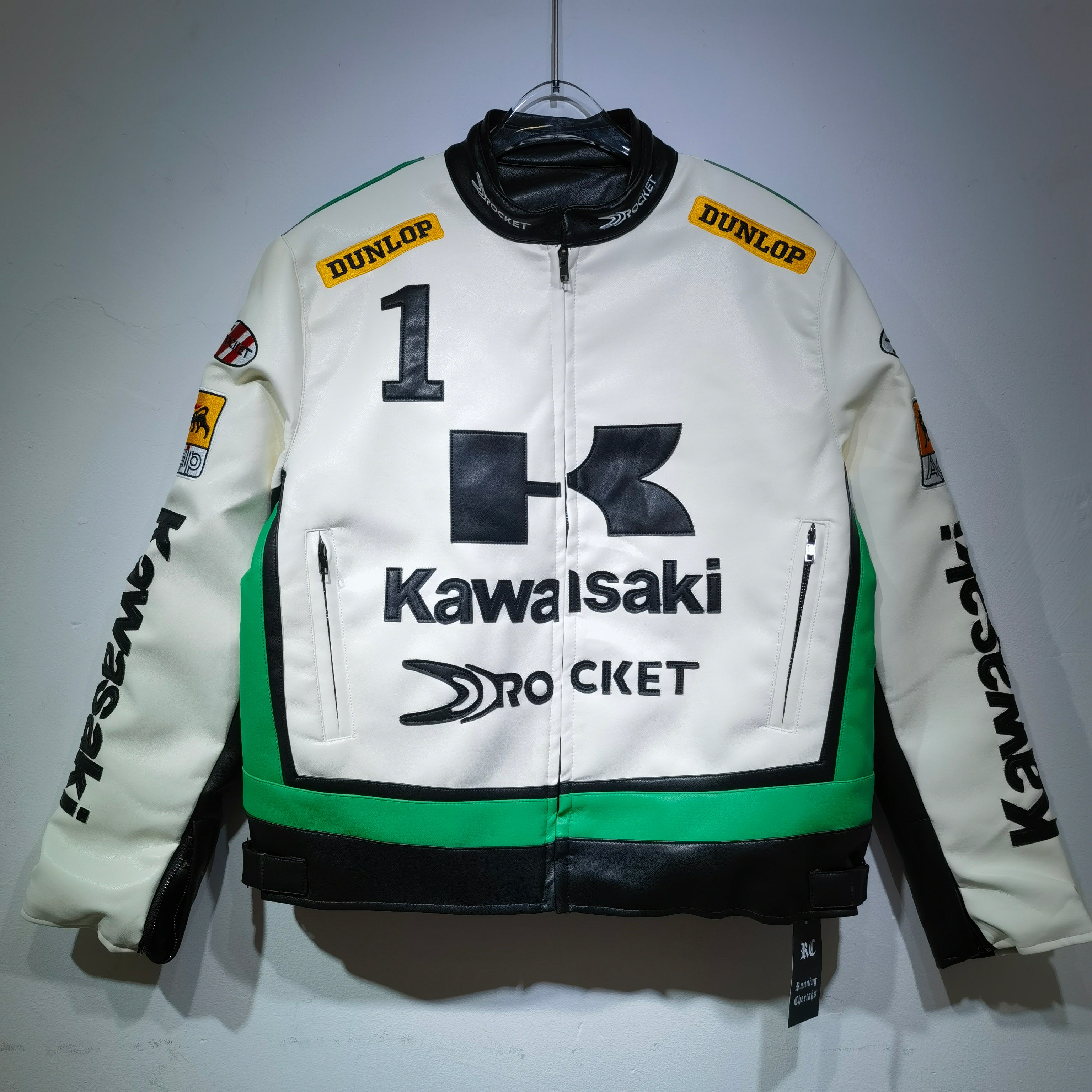 White motorcycle jacket with Kawasaki and Dunlop branding on a gray background