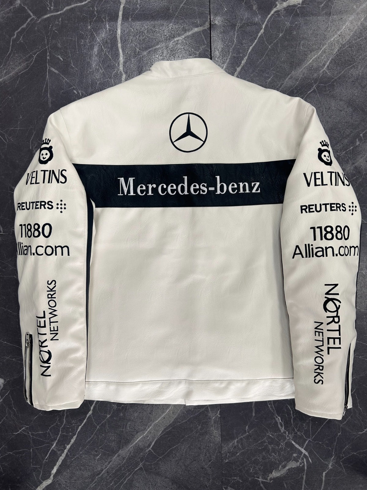 White racing jacket with Mercedes-Benz logo and various sponsor names on a dark marble background
