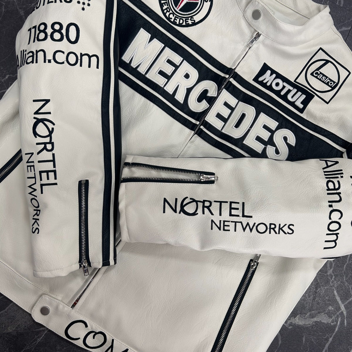 White jacket with Mercedes-Benz and Nortel Networks branding on a dark textured background