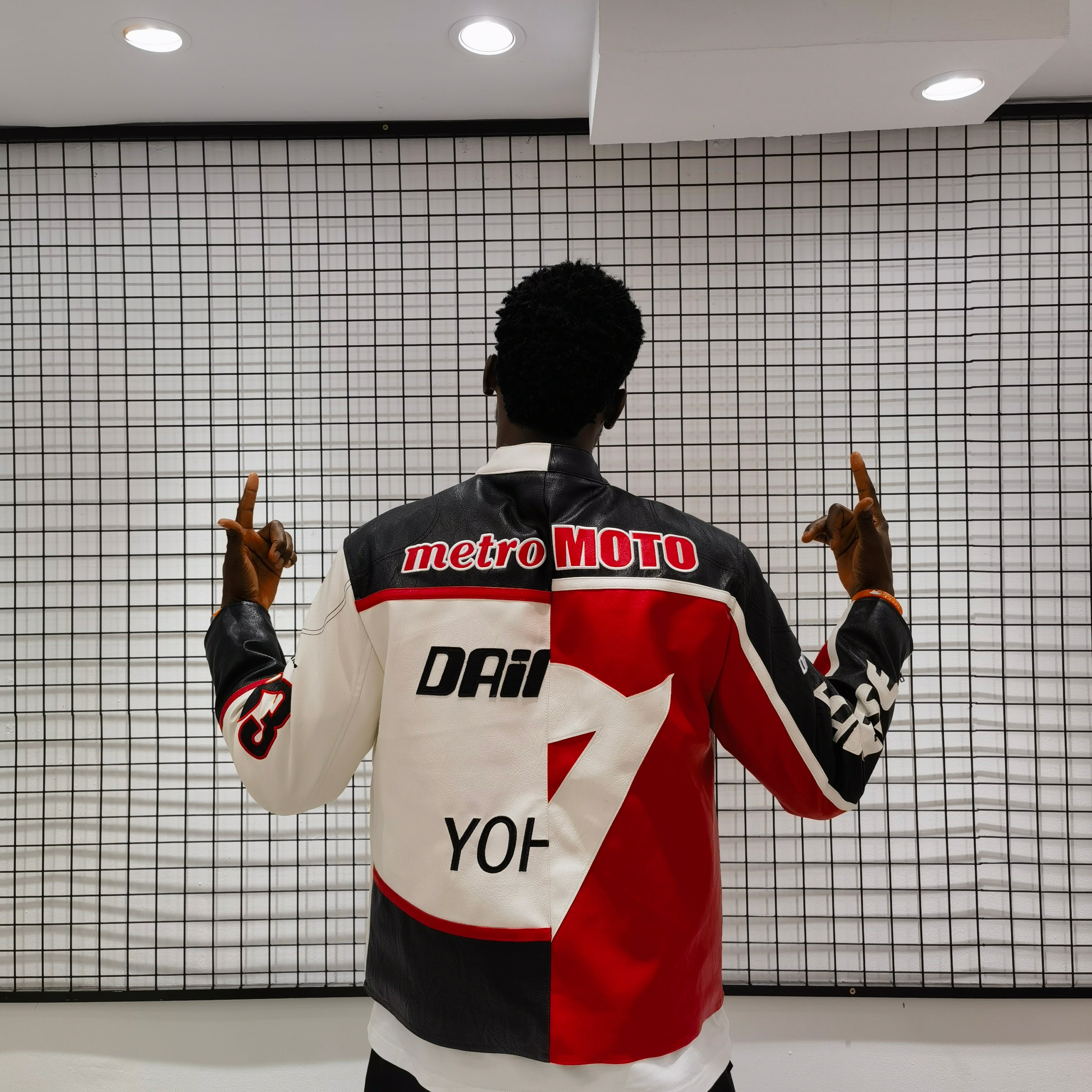 Person wearing a colorful jacket with brand logos in a modern indoor setting