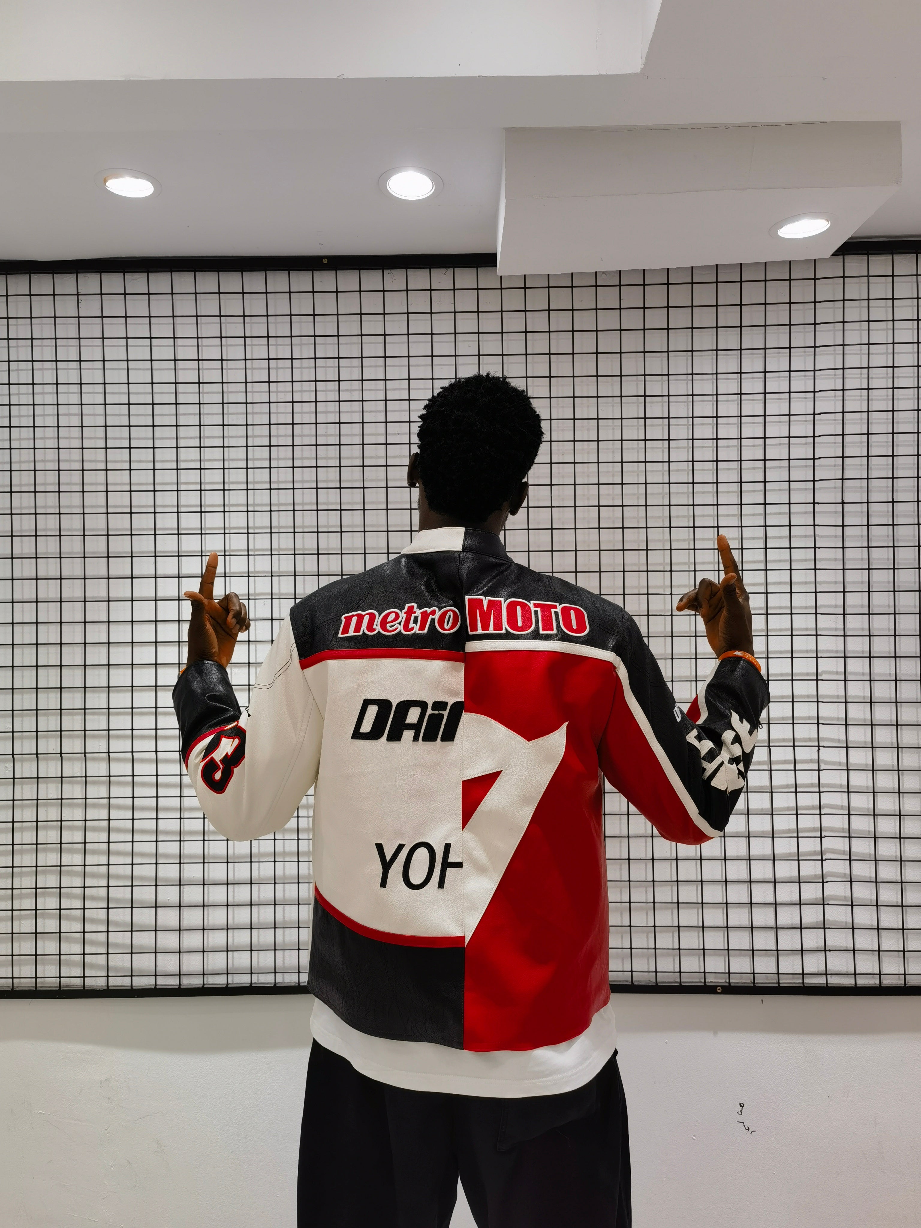 Person wearing a colorful jacket with brand logos in a modern indoor setting