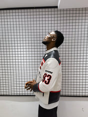 Man wearing a sports jersey with a grid-patterned wall in the background