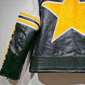 Black leather jacket with a yellow star patch on a neutral background