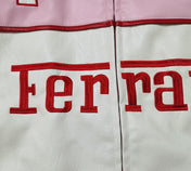Close-up of a Ferrari logo on a white and pink background