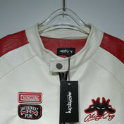 White leather jacket with red accents and patches on a hanger