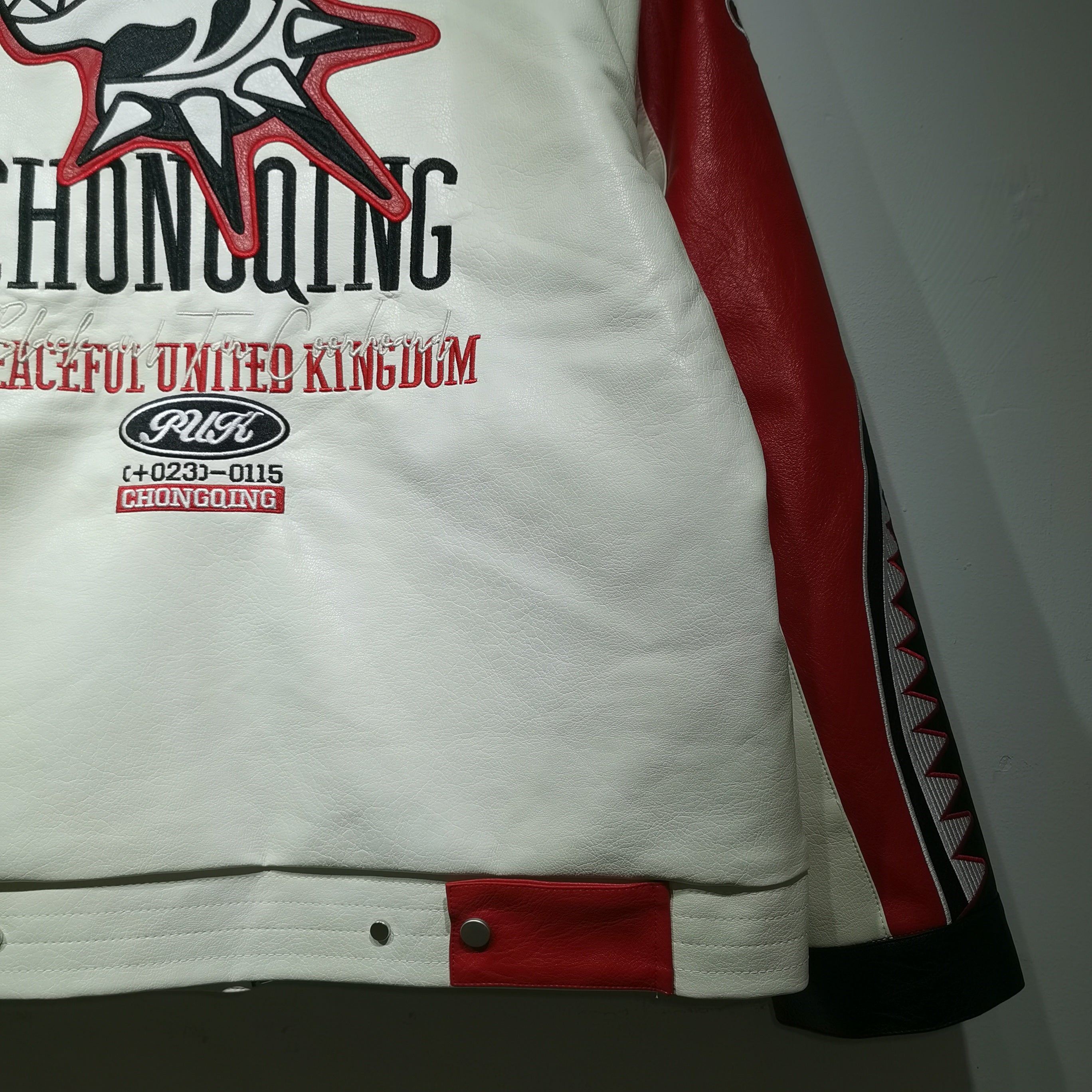 White jacket with red and black accents featuring text and logos on a plain background