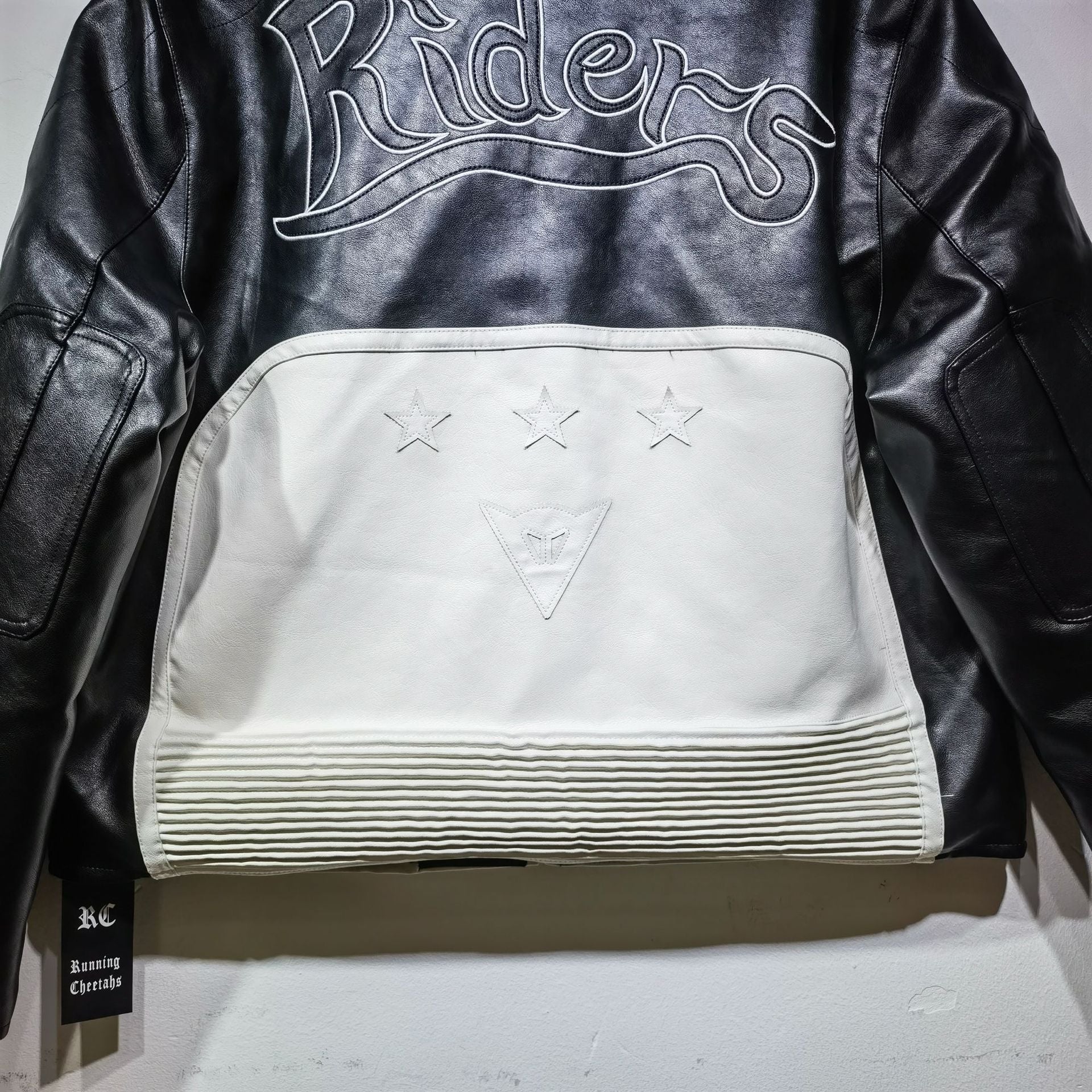 Black leather jacket with 'Riders' embroidery on a white background