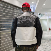 Person wearing a black and white jacket with 'Riders' branding in an indoor setting.