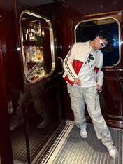 Person standing in a room with wooden paneling and a mirror.