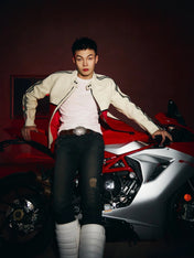 Person sitting on a red sports car with a dark background